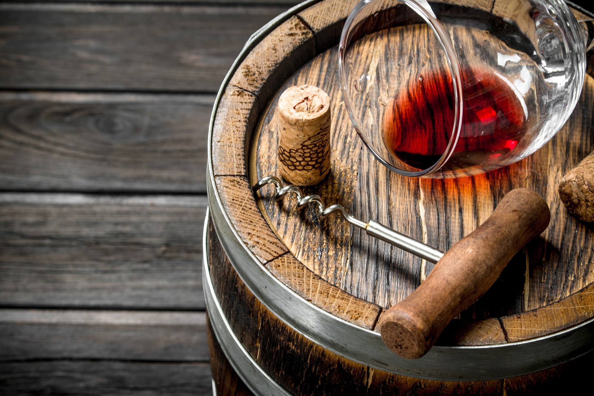 Wine background. A barrel of red wine and a corkscrew.